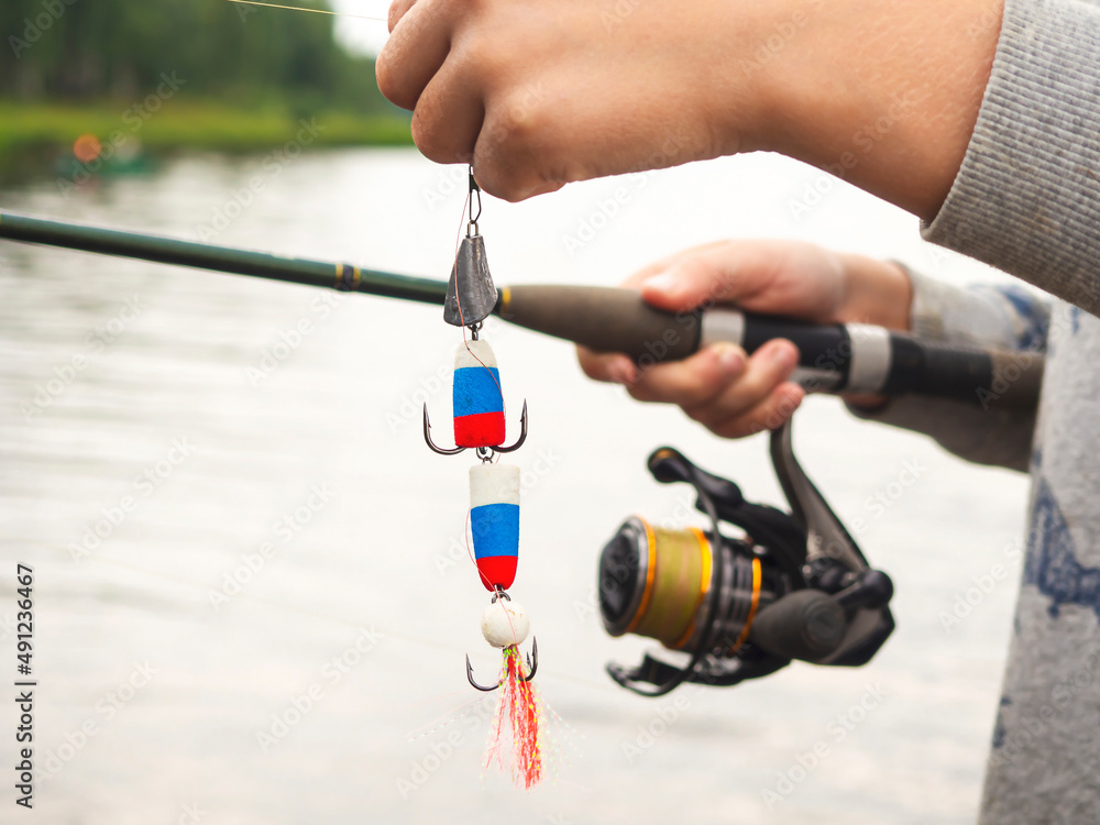 The concept of nature. People way of life food concept. Hands of a child holding a spinning rod.The process of catching fish. The concept of nature. People way of life food concept. Hands of a child holding a spinning rod.The process of catching fish.