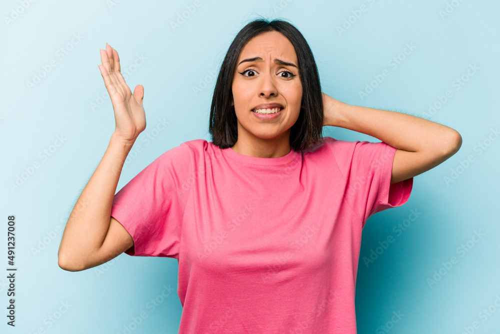 Young hispanic woman isolated on blue background screaming with rage. Young hispanic woman isolated on blue background screaming with rage.