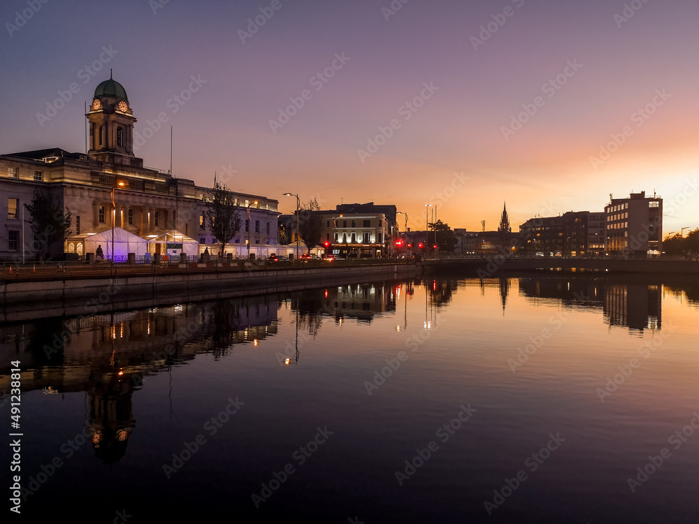 Sunset in Cork City Ireland business and classic buildings with reflection on the river