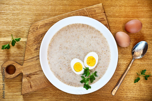 Traditional Polish soup served with bread and eggs. Easter decoration. Sour soup