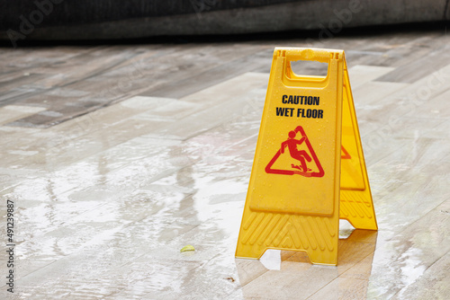 caution wet floor sign on wet floor after raining. photo