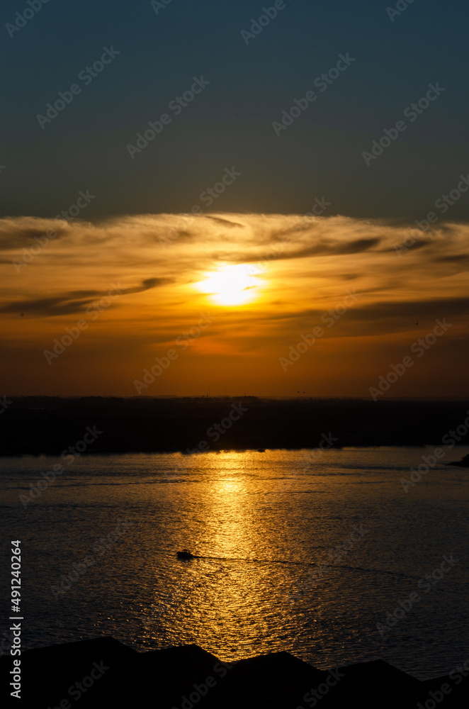 Naklejka premium sunset scene at a lake with some boats silhouettes 
