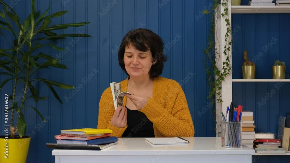 Middle aged woman holding in hands money cash dollars. money plan, save money and management concept Middle aged woman holding in hands money cash dollars. money plan, save money and management concept