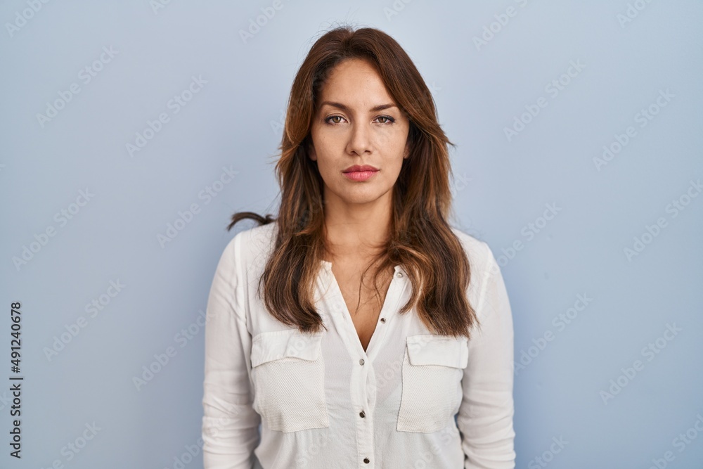 Hispanic woman standing over isolated background relaxed with serious expression on face. simple and natural looking at the camera. Hispanic woman standing over isolated background relaxed with serious expression on face. simple and natural looking at the camera.