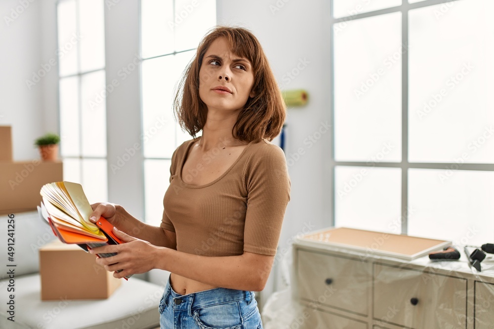 Young caucasian woman choosing wall color at home Young caucasian woman choosing wall color at home