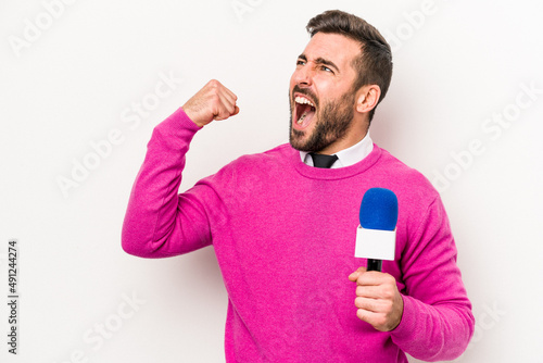 Young caucasian tv presenter man isolated on white background raising fist after a victory, winner concept.