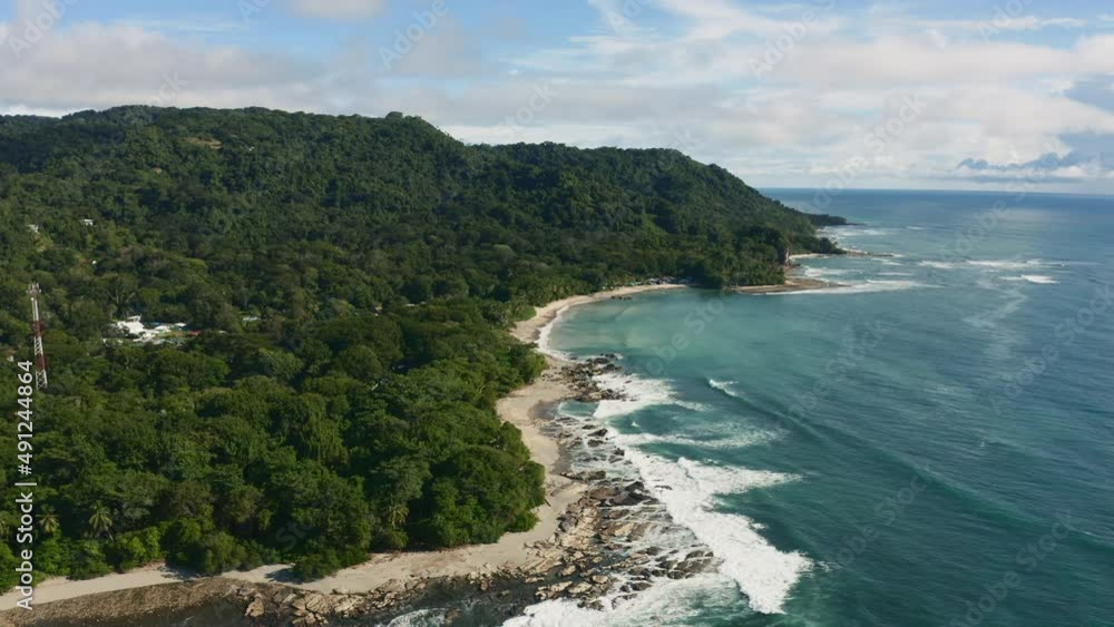 Aerial view over waves crashing the coast sunny Costa Rica - reverse, drone shot Aerial view over waves crashing the coast sunny Costa Rica - reverse, drone shot