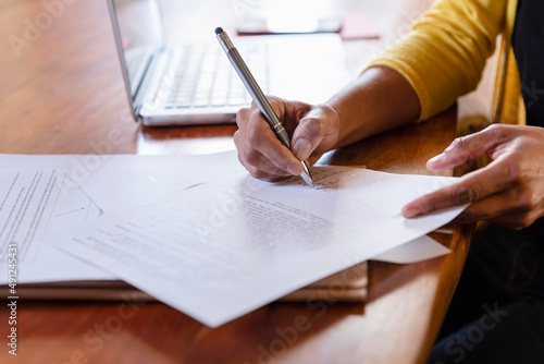 Freelancer signing paper document on desk at home photo