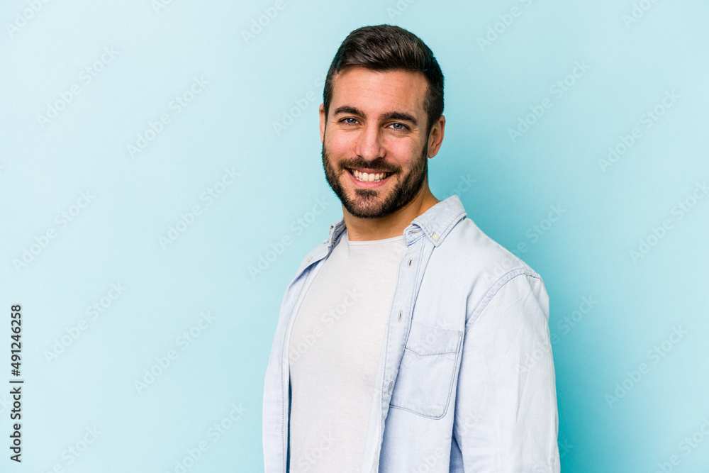 Young caucasian man isolated on blue background confident keeping hands on hips. Young caucasian man isolated on blue background confident keeping hands on hips.