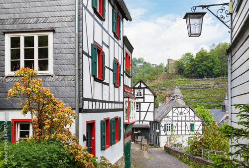 Germany, North Rhine-Westphalia, Monschau, Half-timbered townhouses along street in medieval town photo