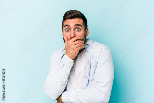 Young caucasian man isolated on blue background scared and afraid.