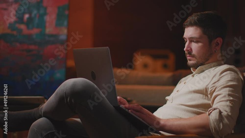 Creative man painter designer working on laptop in art workshop, answer customers, surching inspiration for new project