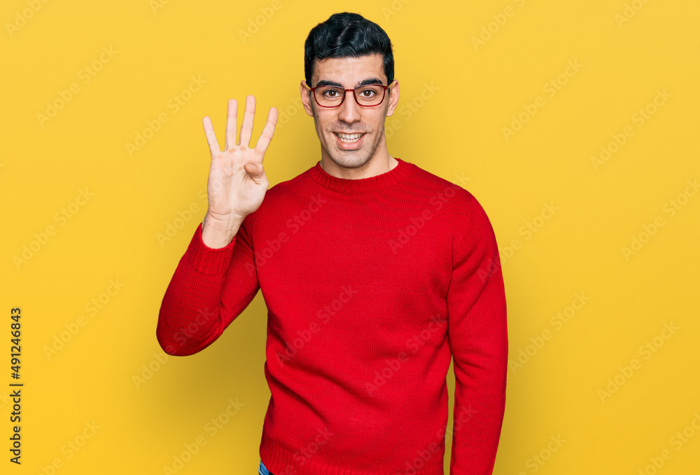Handsome hispanic man wearing casual clothes and glasses showing and pointing up with fingers number four while smiling confident and happy. Handsome hispanic man wearing casual clothes and glasses showing and pointing up with fingers number four while smiling confident and happy.