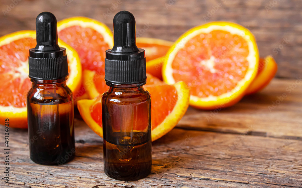 Grapefruit essential oil in a small bottle. Selective focus. Grapefruit essential oil in a small bottle. Selective focus.