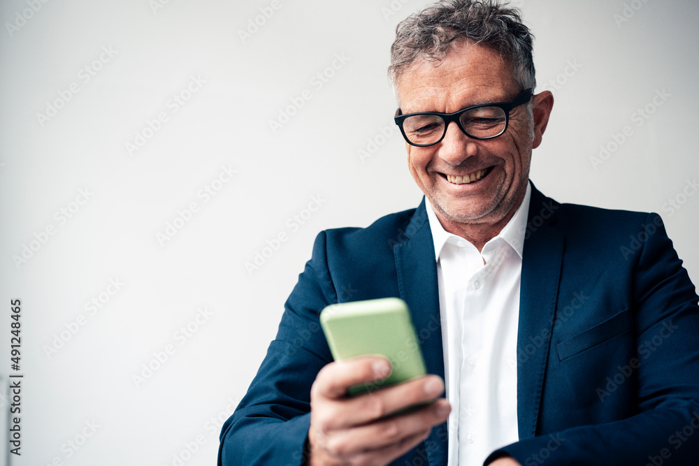 Happy businessman using smart phone against white background in studio Happy businessman using smart phone against white background in studio