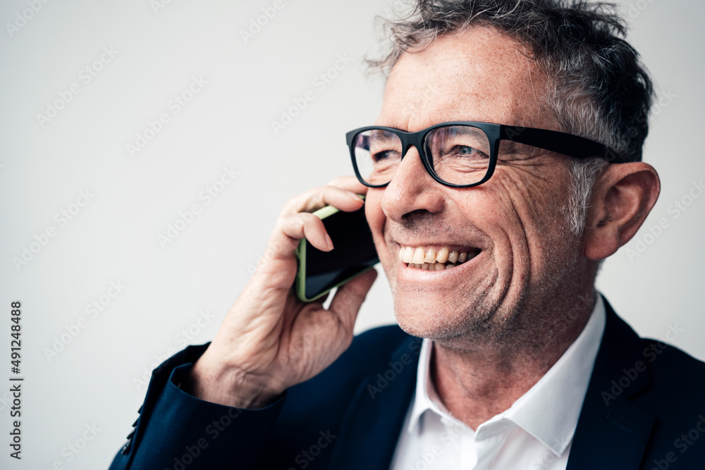 Cheerful businessman talking on smart phone at studio Cheerful businessman talking on smart phone at studio