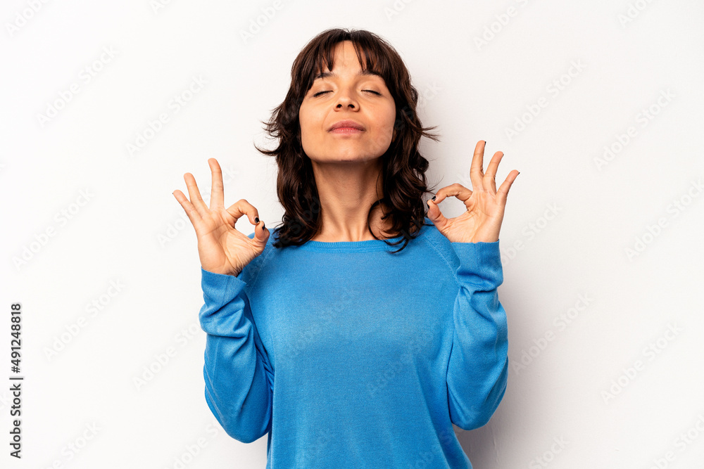 Young hispanic woman isolated on white background relaxes after hard working day, she is performing yoga. Young hispanic woman isolated on white background relaxes after hard working day, she is performing yoga.