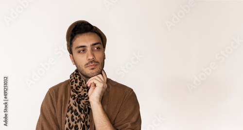 An artist seems like he is corious about something. Man wearing scarf with leopard pattern. Close up expressions on isolated background. photo