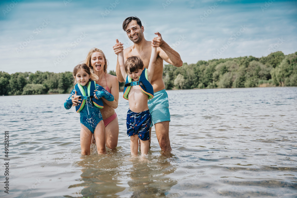 Happy family standing in lake on weekend