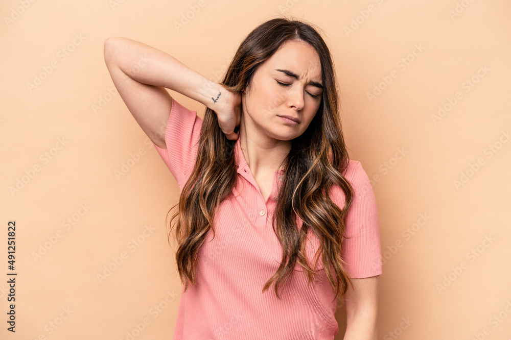 Young caucasian woman isolated on beige background massaging elbow, suffering after a bad movement. Young caucasian woman isolated on beige background massaging elbow, suffering after a bad movement.