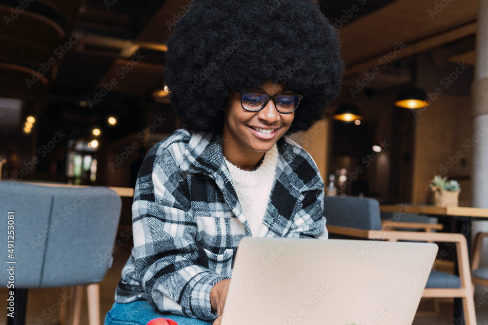 Young afro businesswoman using laptop in coffee shop Young afro businesswoman using laptop in coffee shop