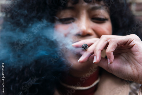 Smiling young woman smoking cigarette photo