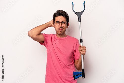 Young caucasian man holding a garbage collector isolated on white background being shocked, she has remembered important meeting.