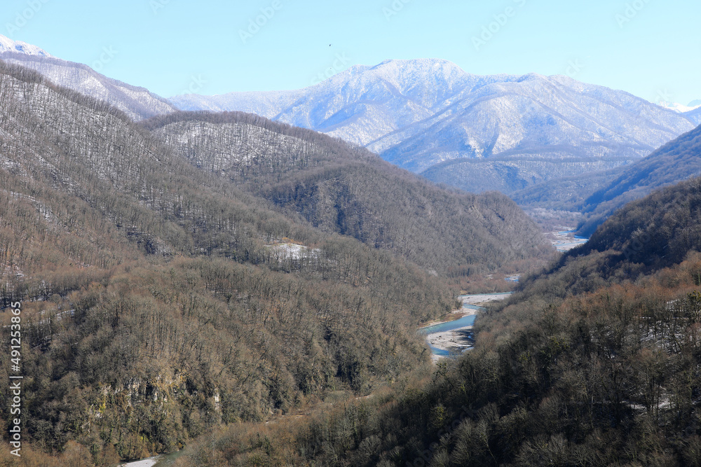 View of the clear mountain river in the gorge. Caucasian mountains with snow-capped peaks. The Shahe River. Solokhaul, Sochi, Russia. View of the clear mountain river in the gorge. Caucasian mountains with snow-capped peaks. The Shahe River. Solokhaul, Sochi, Russia.