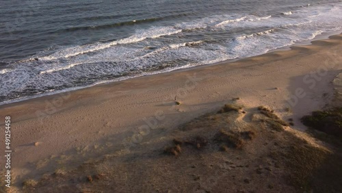 Wallpaper Mural Aerial view of solo traveler walking on an isolated beach during sunset. Torontodigital.ca