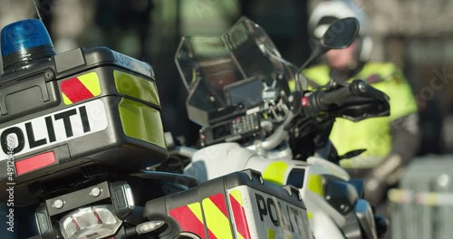 Norwegian police patrol motorcycle with officer in blurry background - handheld photo