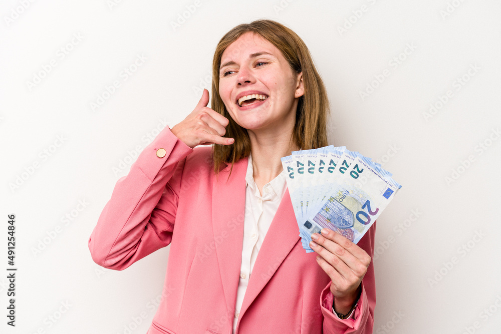 Young business English woman holding banknotes isolated on white background showing a mobile phone call gesture with fingers. Young business English woman holding banknotes isolated on white background showing a mobile phone call gesture with fingers.