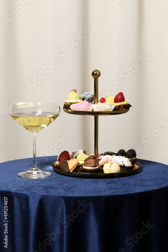 Vintage vase with mini cakes and glass of wine