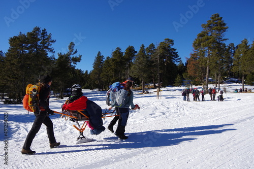 Randonnée solidaire avec handicapés en fauteuil roulant et aveugles sur la neige avec des raquettes et des patins en montagne en hiver