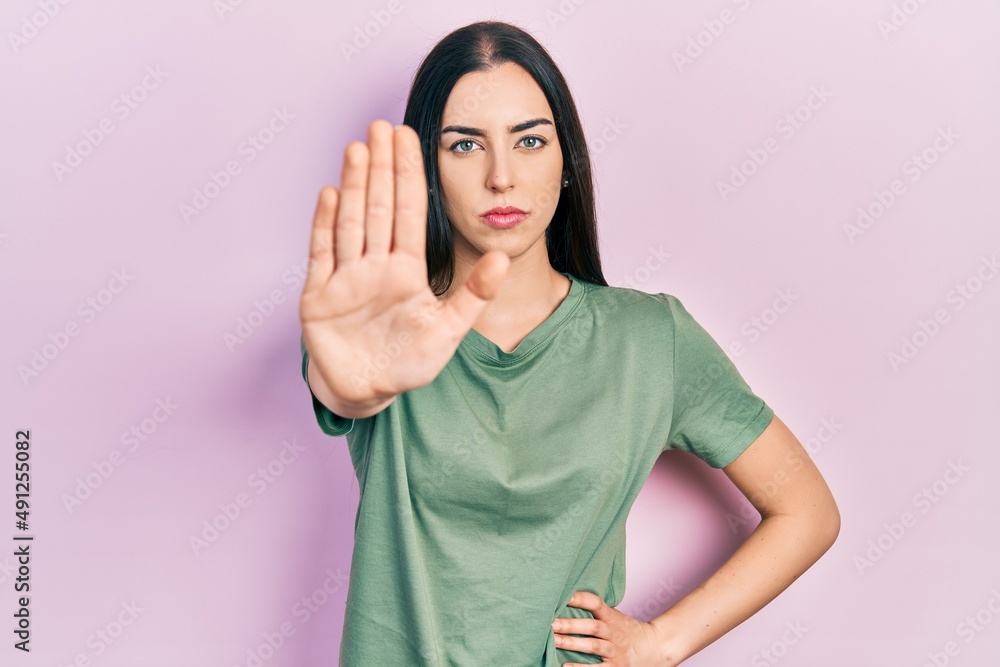 Beautiful woman with blue eyes wearing casual t shirt doing stop sing with palm of the hand. warning expression with negative and serious gesture on the face. Beautiful woman with blue eyes wearing casual t shirt doing stop sing with palm of the hand. warning expression with negative and serious gesture on the face.