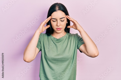 Beautiful woman with blue eyes wearing casual t shirt with hand on head for pain in head because stress. suffering migraine. © Krakenimages.com
