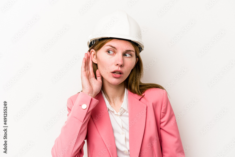 Young architect English woman with helmet isolated on white background trying to listening a gossip. Young architect English woman with helmet isolated on white background trying to listening a gossip.