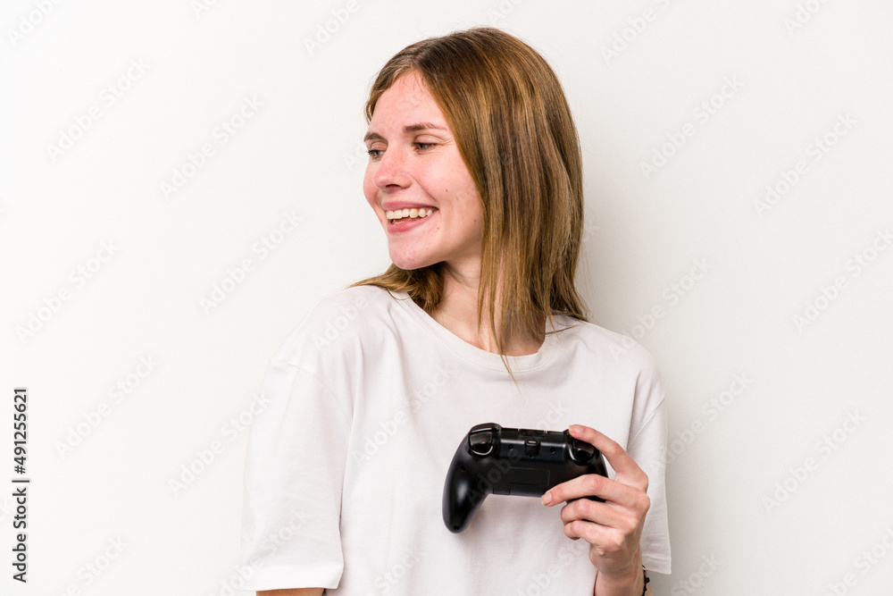 Young English woman playing with a video game controller isolated white background looks aside smiling, cheerful and pleasant. Young English woman playing with a video game controller isolated white background looks aside smiling, cheerful and pleasant.