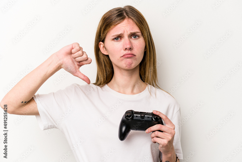 Young English woman playing with a video game controller isolated white background showing a dislike gesture, thumbs down. Disagreement concept. Young English woman playing with a video game controller isolated white background showing a dislike gesture, thumbs down. Disagreement concept.