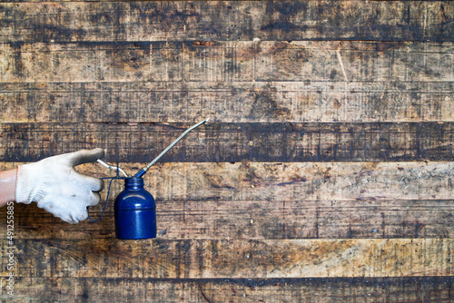 Maintenance worker holding oil cans on wooden floor,Lube oil can and used in industry or machinery lubricants