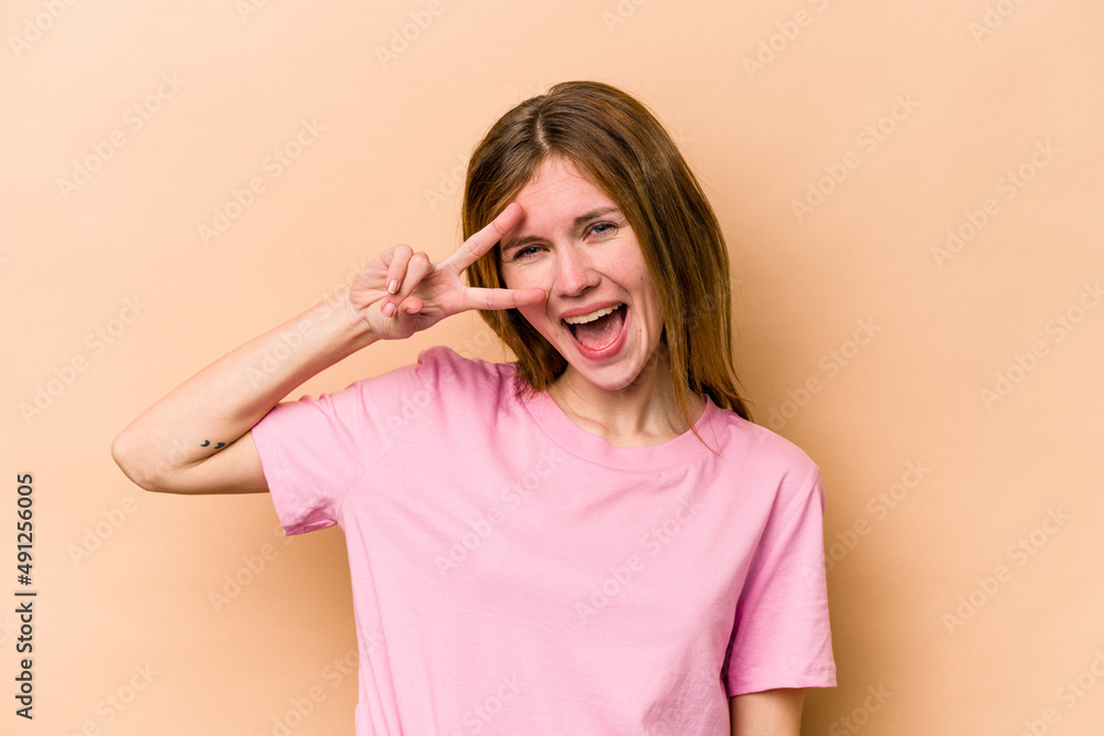 Young English woman isolated on beige background dancing and having fun. Young English woman isolated on beige background dancing and having fun.