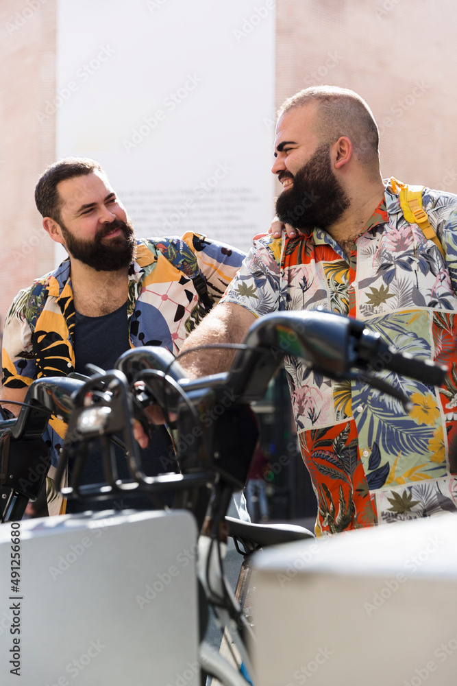 Obraz premium Young gay tourist couple outdoors. They are smiling and wearing summer clothes. 