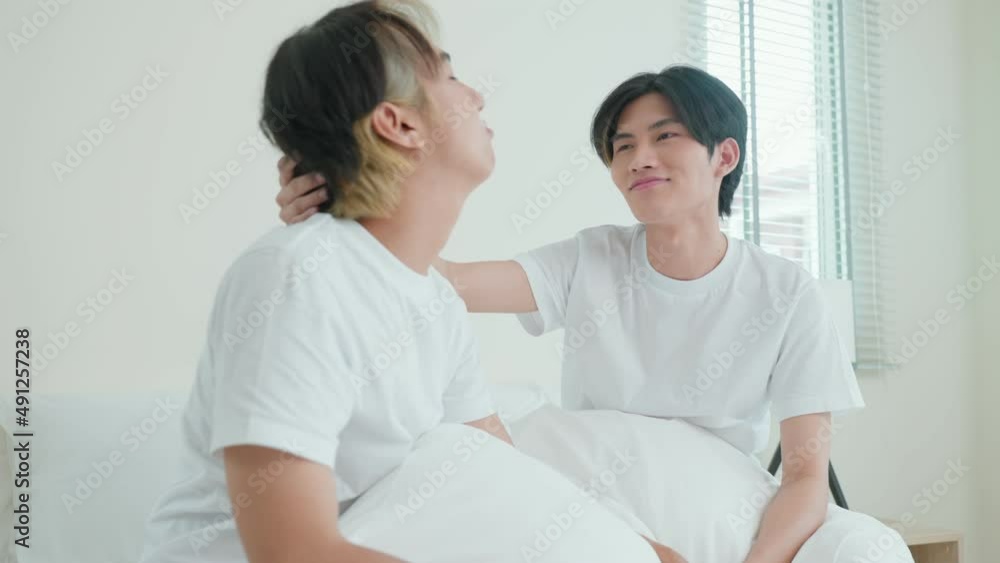 Asian handsome male gay couple sitting on bed and look at each other. Asian handsome male gay couple sitting on bed and look at each other.