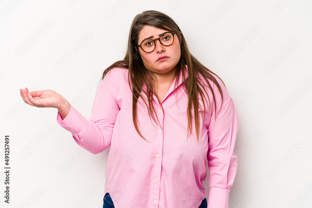 Young caucasian overweight woman isolated on white background doubting and shrugging shoulders in questioning gesture. Young caucasian overweight woman isolated on white background doubting and shrugging shoulders in questioning gesture.