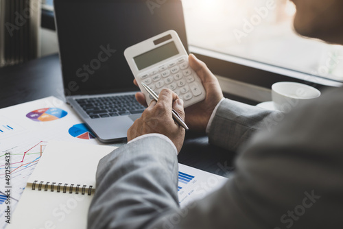 Businessman working on desk office with using a calculator to calculate the numbers. Accounting Concepts and Financial Planning