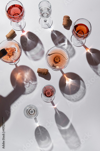 Wine glasses on grey background. Direct sunlight, aesthetic still life