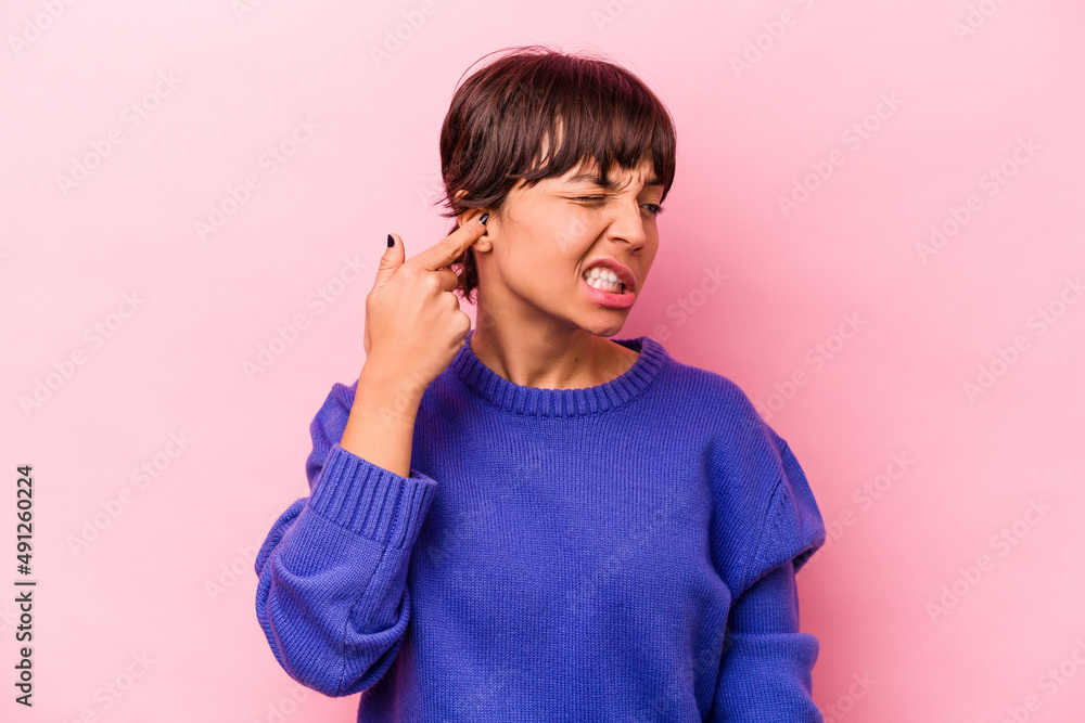 Young hispanic woman isolated on pink background covering ears with hands. Young hispanic woman isolated on pink background covering ears with hands.