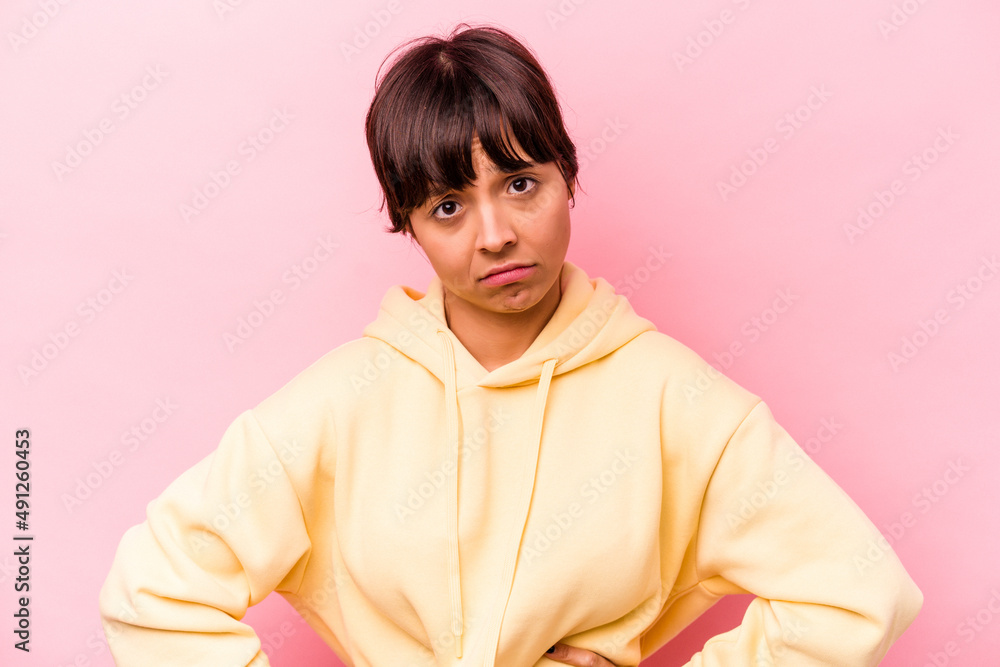Obraz premium Young hispanic woman isolated on pink background sad, serious face, feeling miserable and displeased.