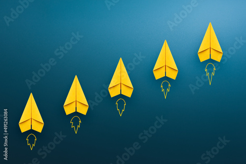 Fotografía Yellow paper plane on blue background, Success in business growth concept