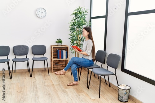 Young asian woman reading a book at waiting room