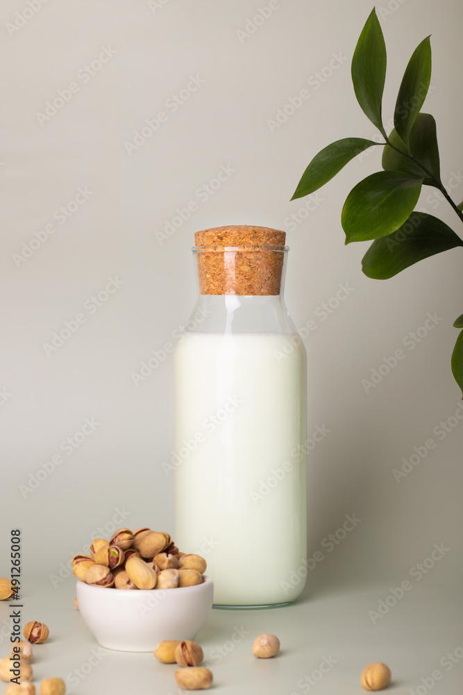Minimalistic representation of plant-based pistachio milk, displayed with fresh nuts on a light backdrop. Minimalistic representation of plant-based pistachio milk, displayed with fresh nuts on a light backdrop.
